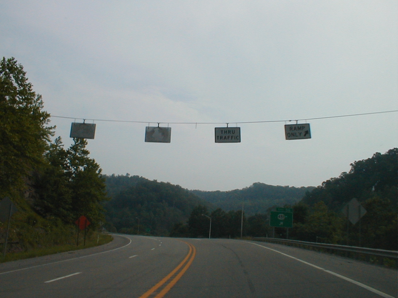 Overhead signage for "thru traffic" and "ramp only" while heading west at Exit 56.