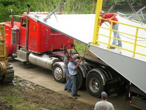 Brian Froedge and Joe Stephens unchain the new KY 214 ferry from the tractor trailer.