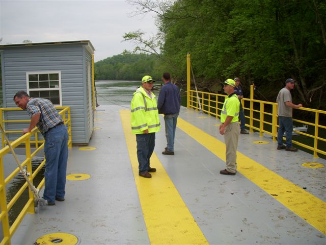 Brian Froedge peers over the side with a giant smile of relief. She floats! Brian's company (Grandview Welding and Equipment Company) constructed the new ferry in approximately 10 weeks.