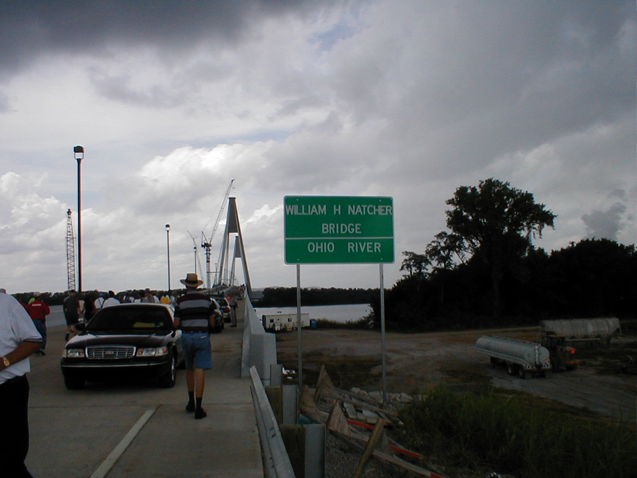 Visitors pass by the "William H. Natcher Bridge" sign as they begin their walk across the bridge.